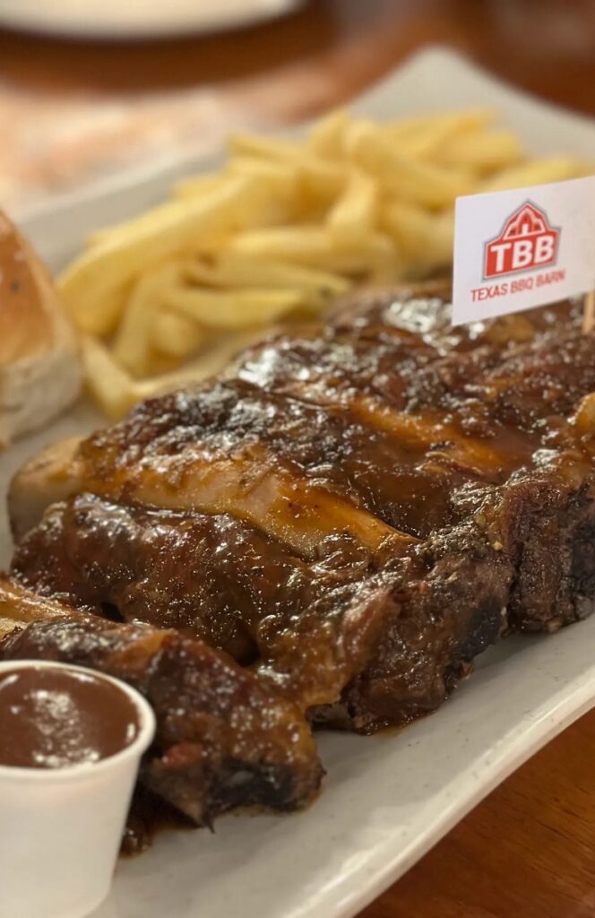 Juicy smoked prime rib glazed with BBQ sauce, showcasing tender meat and a perfectly charred bark.